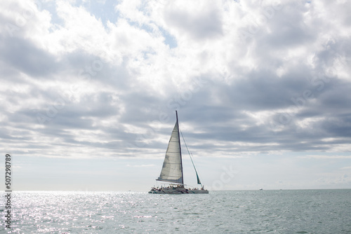 The white sails of yachts on the background of sea and sky in the clouds