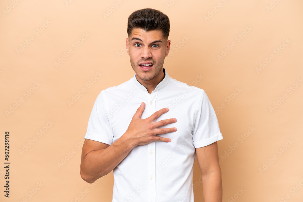 Young caucasian man isolated on beige background pointing to oneself