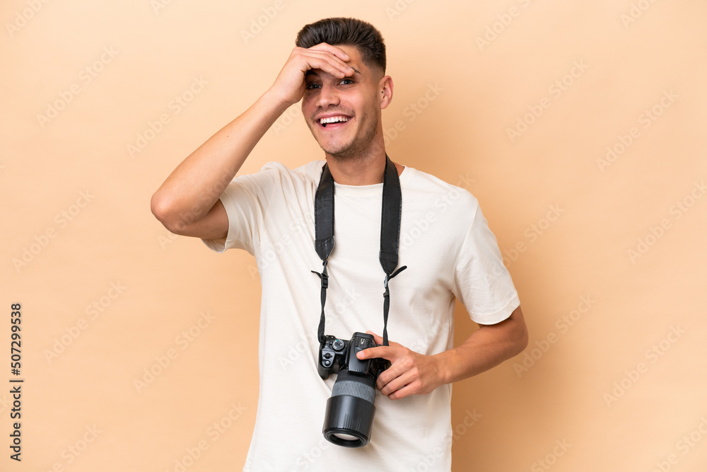 Young photographer caucasian man isolated on beige background looking far away with hand to look something Young photographer caucasian man isolated on beige background looking far away with hand to look something