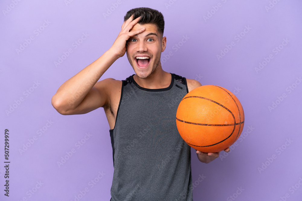 Fototapeta premium young caucasian woman basketball player man isolated on purple background with surprise expression