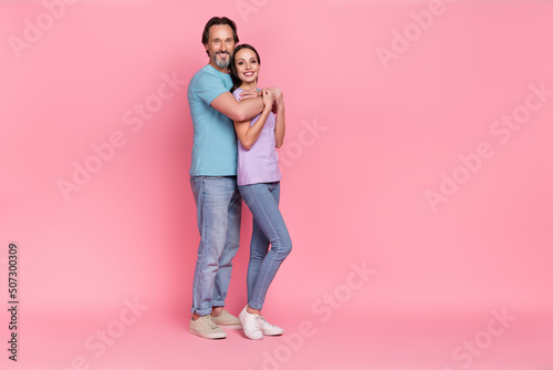 Full length photo of two peaceful cheerful people embrace toothy smile isolated on pink color background