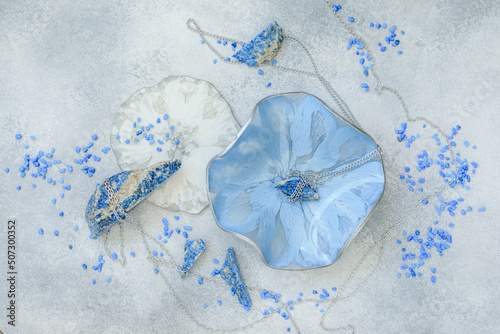 Composition with Resin art plates and natural blue stones on gray. Flat lay, top view