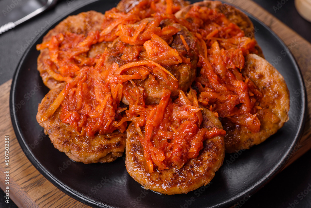 Meatballs with tomato sauce and herbs on the black plate Meatballs with tomato sauce and herbs on the black plate