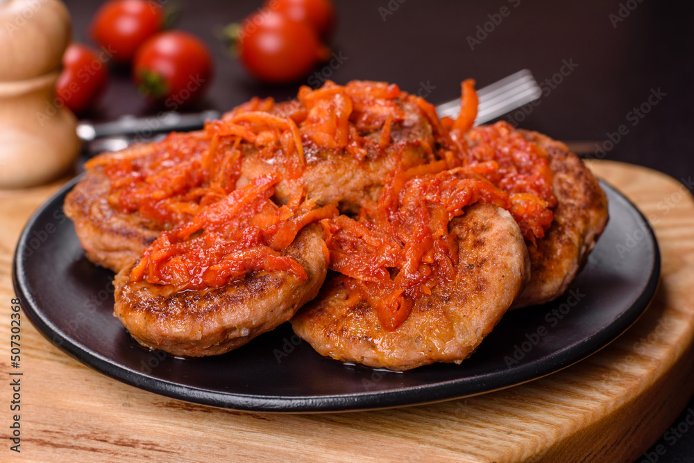 Meatballs with tomato sauce and herbs on the black plate Meatballs with tomato sauce and herbs on the black plate