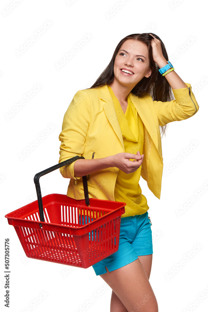 Happy casual woman standing with empty shopping cart basket looking out of frame Happy casual woman standing with empty shopping cart basket looking out of frame