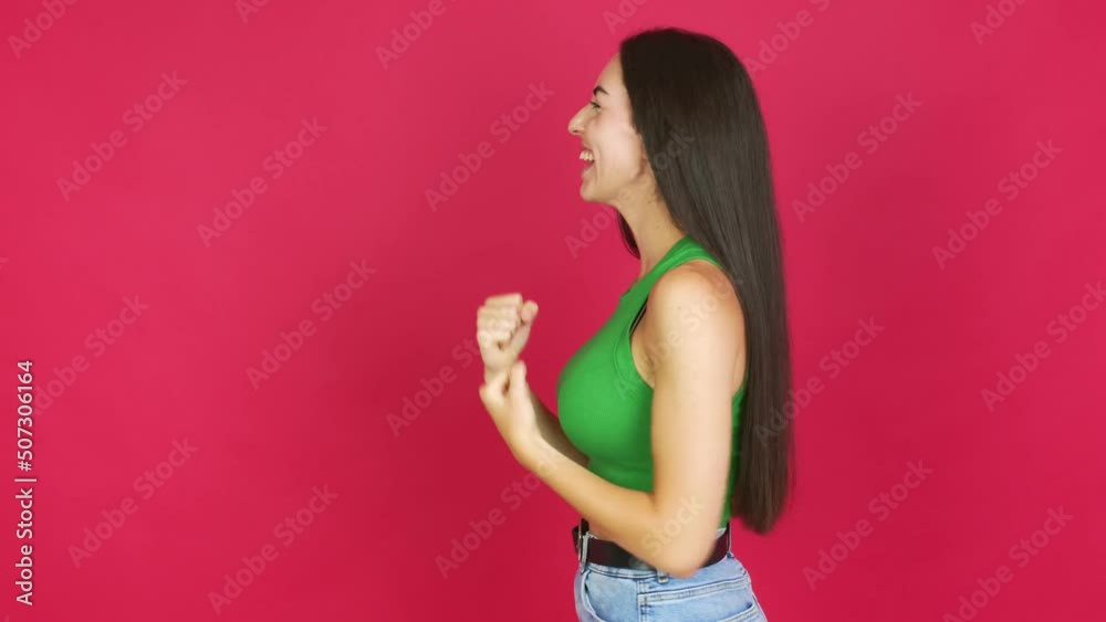 Young brunette woman celebrating a victory over isolated background Young brunette woman celebrating a victory over isolated background