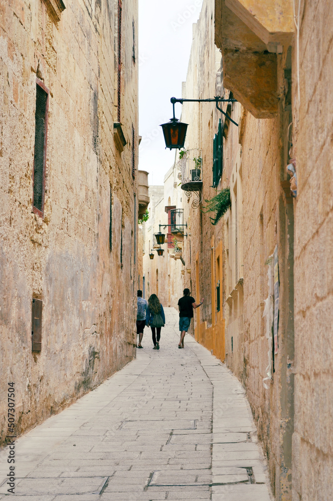 Typical narrow street with an ancient stone buildings in Mdina, Malta island.Mdina is a fortified city in the Northern Region of Malta which served as the island capital and is also called Silent Sity