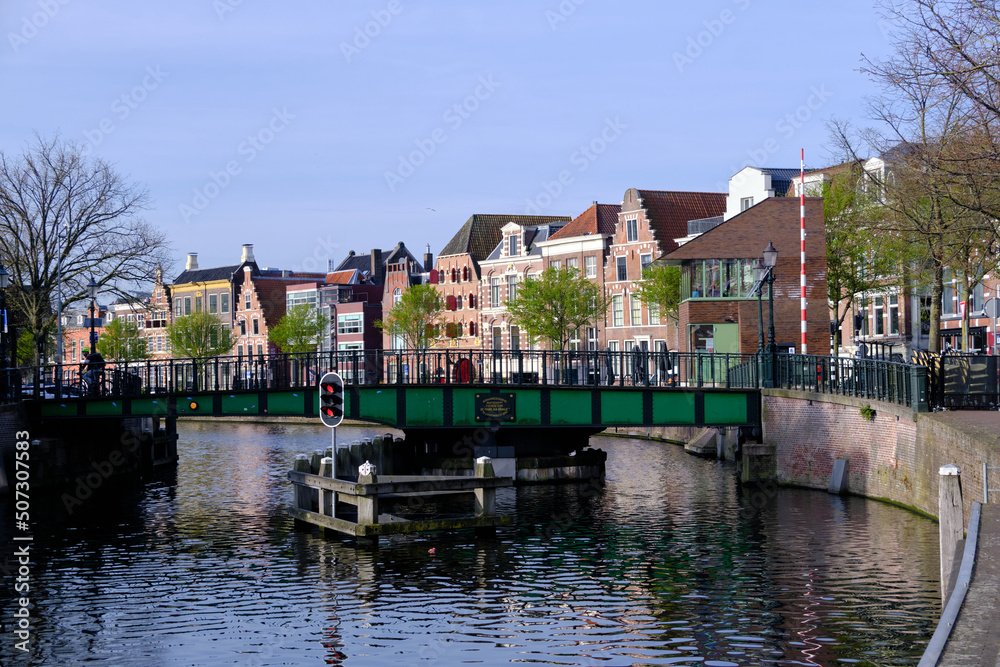 Haarlem, Netherlands - April 12. 2022: View over river Sparne towards old green swing bridge (Melkbrug) in springtime.