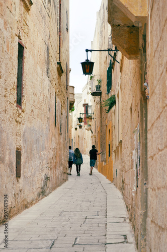 Typical narrow street with an ancient stone buildings in Mdina, Malta island.Mdina is a fortified city in the Northern Region of Malta which served as the island capital and is also called Silent Sity © Victoria