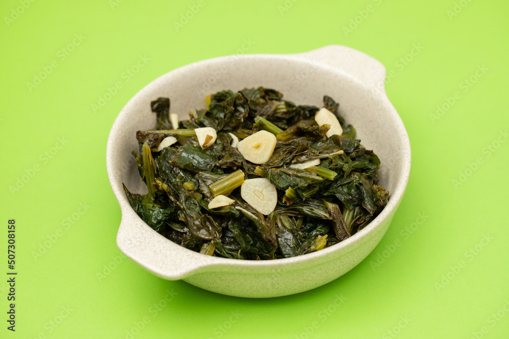 fried spinach with garlic in small gray bowl fried spinach with garlic in small gray bowl