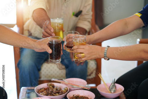 Group of friends sitting on a summer terrace with beer and wine in their hands and snacks on the table              