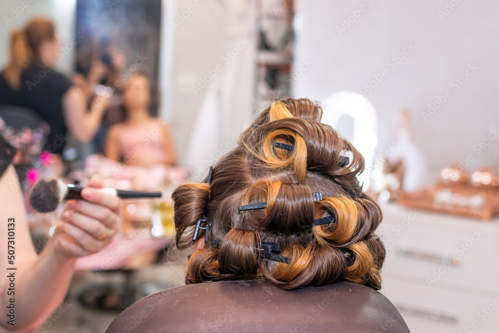 Bride's hair styled with bobby pins in the beauty salon before the wedding