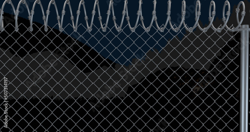 Image of fence with barbed wire over view of mountain