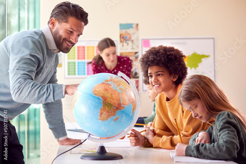 Fotografia Group Of Multi-Cultural Students With Teachers In Classroom Looking At Globe In