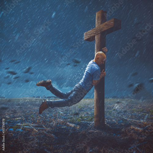 Man clinging to cross © Kevin Carden