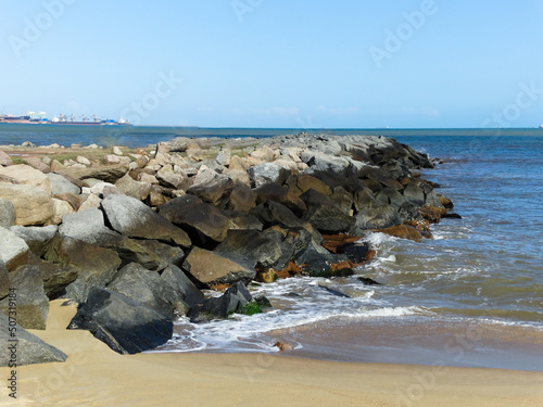 Lindo Mirante feito com grandes pedras, banhado pelas ondas do mar, com céu azul. Fotografado em Vitória no estado do Espírito Santo, Brasil. photo