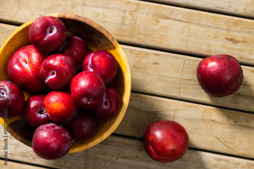 Directly above shot of fresh peaches in bowl over wooden table Directly above shot of fresh peaches in bowl over wooden table