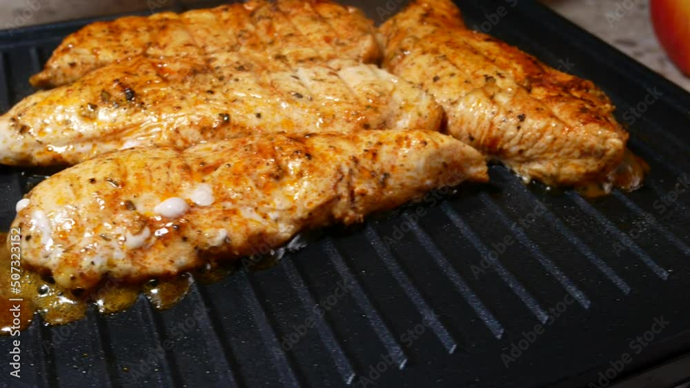 Delicious juicy chicken steak seasoned with herbs and spices is fried in a grill. Barbecue party. Delicious juicy chicken steak seasoned with herbs and spices is fried in a grill. Barbecue party.