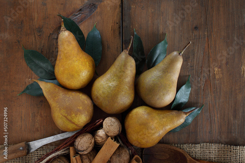 group of ripe pears lie on old planed wooden boards.