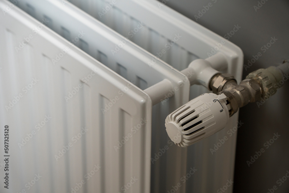 Water radiator close up. Radiator, room interior, grey wall. Interior detail. Home gas heater closeup. Water radiator close up. Radiator, room interior, grey wall. Interior detail. Home gas heater closeup.