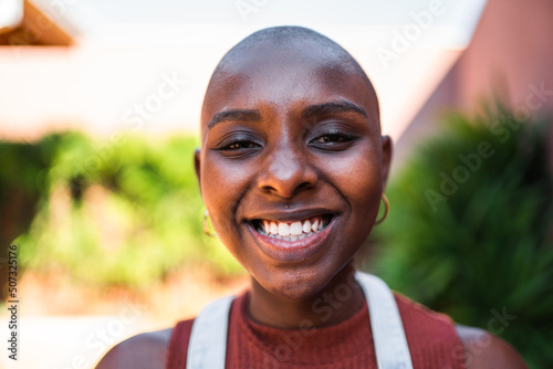 Mulher negra sorrindo com um jardim ao fundo