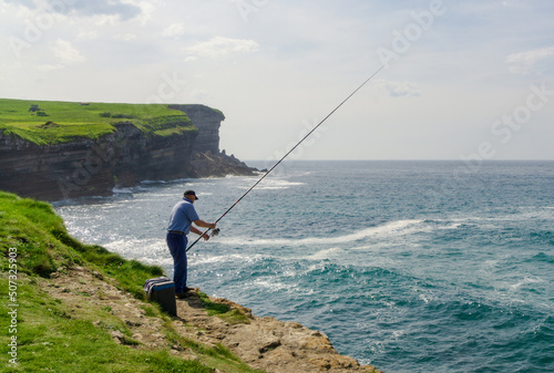 hombre pesca con caña en un acantilado  © Omar