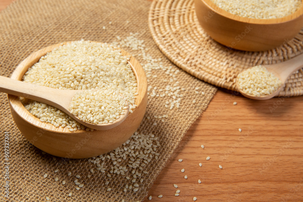 White sesame seeds in wooden spoon and bowl,close up and choose a focus point. White sesame seeds in wooden spoon and bowl,close up and choose a focus point.