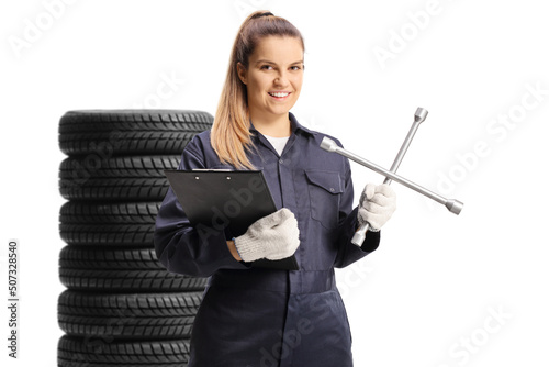 Young female mechanic worker holding a plug wrench and a clipboard
