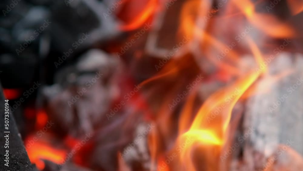 Tongues of flame, the fire burns in the grill. A real fireplace full of wood and fire. Beautiful movement of a bright flame of fire over wooden logs. Embers in bright fire. Slow motion. Tongues of flame, the fire burns in the grill. A real fireplace full of wood and fire. Beautiful movement of a bright flame of fire over wooden logs. Embers in bright fire. Slow motion.