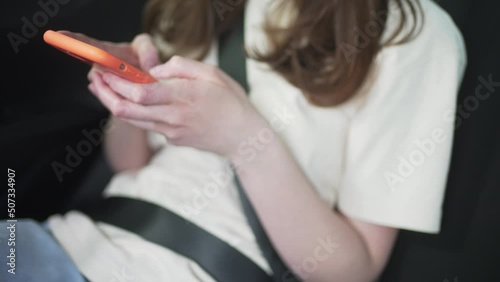 The driver types in the phone, close-up. Woman wearing a seat belt 4K 10 BIT