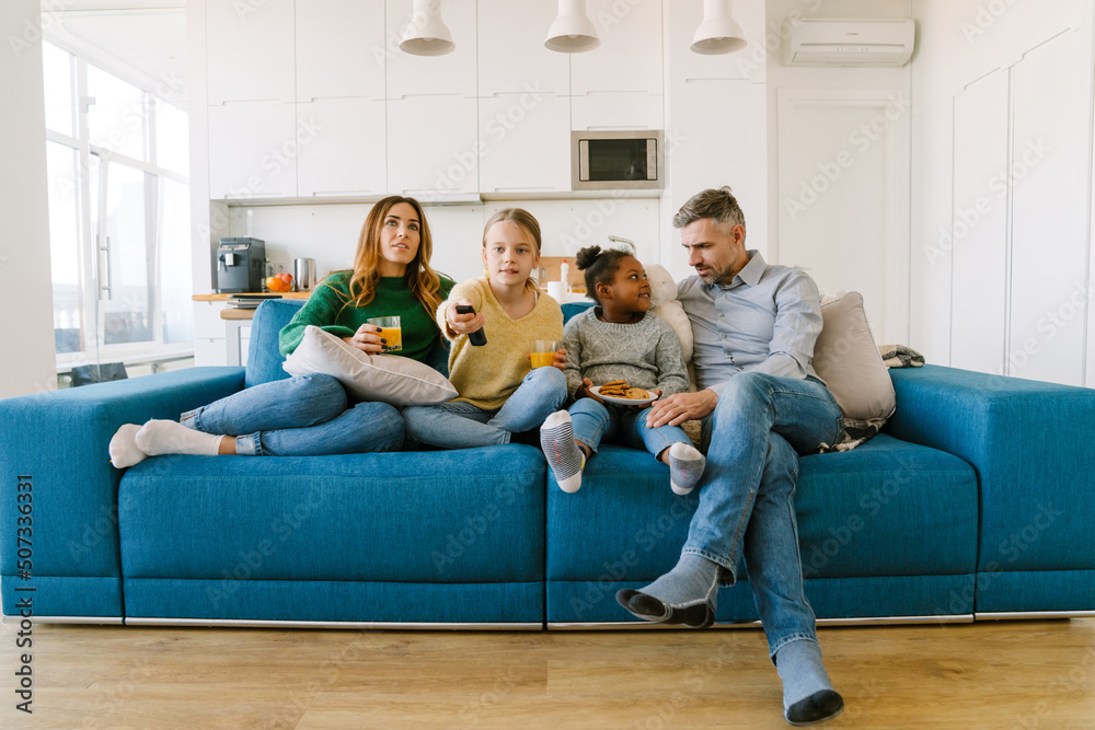 Happy familly sitting on sofa and watching tv