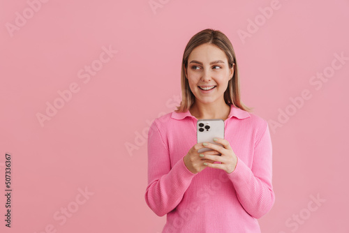 Young handsome girl holding phone and looking leftward