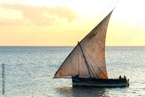 large african sailing dhow on the ocean with a distant blue horizon photo