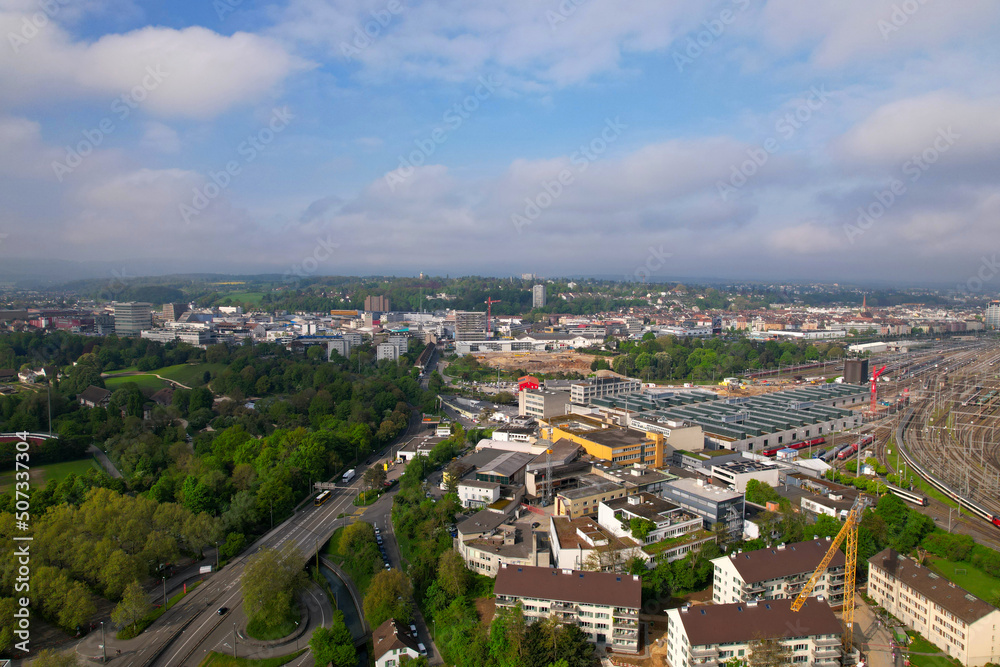 Aerial view of City of Basel with highway and railway track field on a blue cloudy spring day. Photo taken April 27th, 2022, Basel, Switzerland.