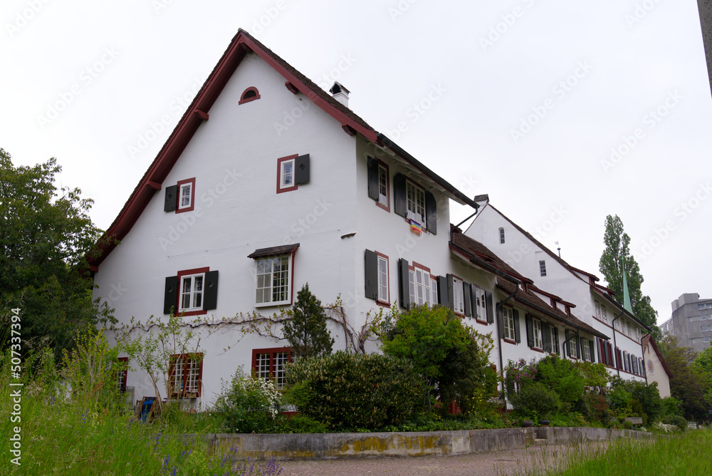 Historic houses with trees and garden at district of St. Jakob at City of Basel on a cloudy spring day. Photo taken April 27th, 2022, Basel, Switzerland.