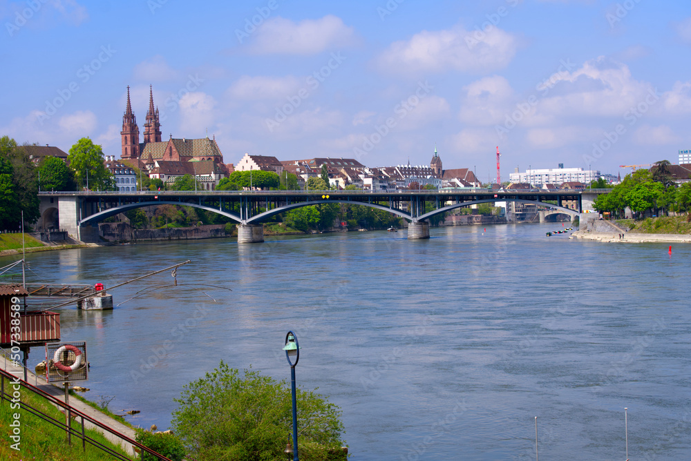 Naklejka premium Skyline of the old town of Basel with Basler Minster and Wettstein Bridge in the foreground on a blue cloud spring day. Photo taken April 27th, 2022, Basel, Switzerland.