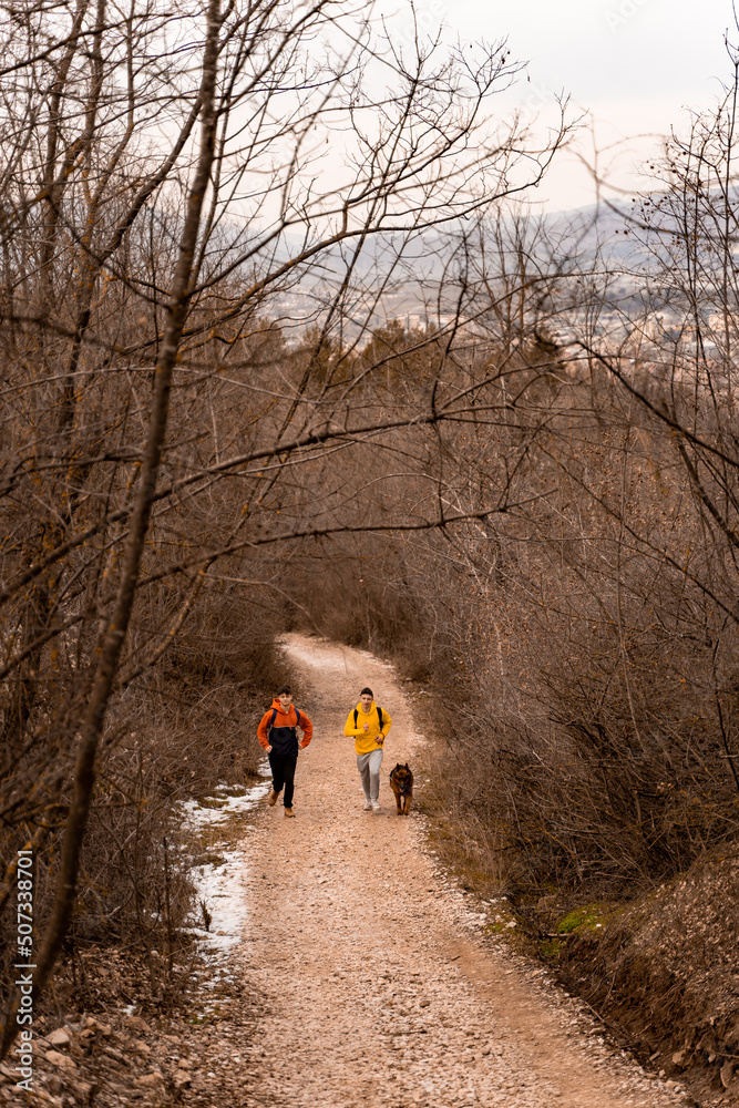 Running with the dog together on the path in the forest