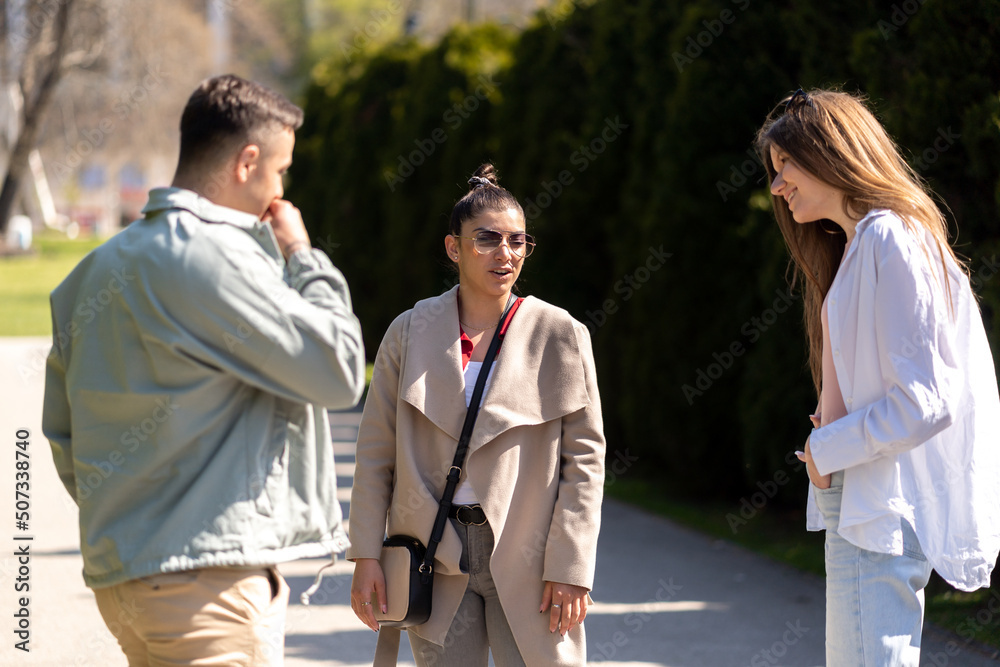 Front view of three students walking and talking in an university campus Front view of three students walking and talking in an university campus