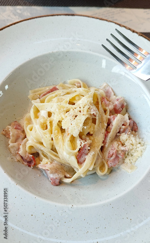 Carbonara pasta. Spaghetti with bacon, cheese and cream sauce, hign angle view in cafe