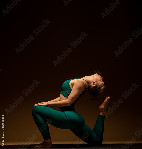 Stretching her back while exercising on the ground  and focusing