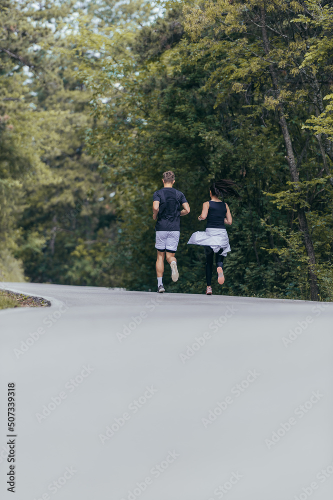Athletic couple running on a street next to each other. Nature,fit and healthy concept. Athletic couple running on a street next to each other. Nature,fit and healthy concept.