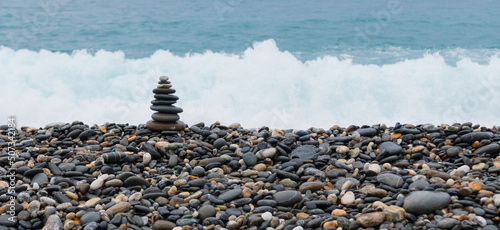 stacked stones, tower or pyramid of stones on the beach, balance, Sea waves background （Hualien, Taiwan）