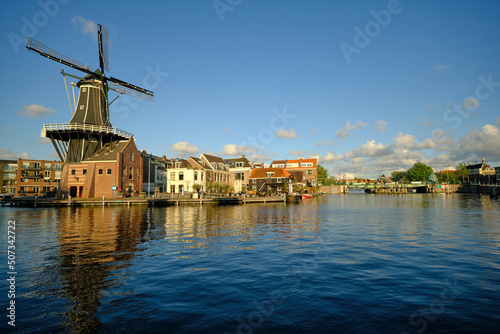 HAARLEM, NETHERLANDS - MAY 24, 2022: The famous Adriaan Windmill on the river De Spaarne on a clear day.