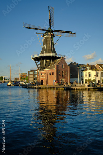 HAARLEM, NETHERLANDS - MAY 24, 2022: The famous Adriaan Windmill on the river De Spaarne on a clear day.