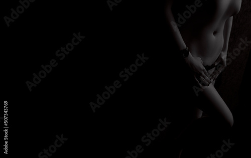 Silhouette of a naked girl on a black background from the edge of the frame, black and white photo