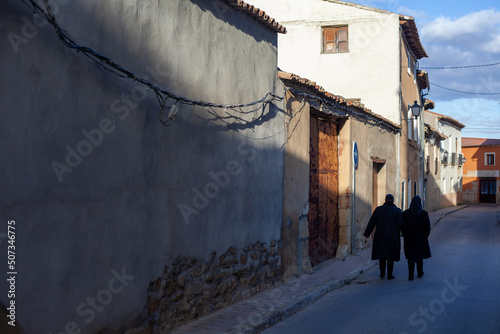 фотографія an elderly couple strolls down a quiet street in a small town in the interior of Spain