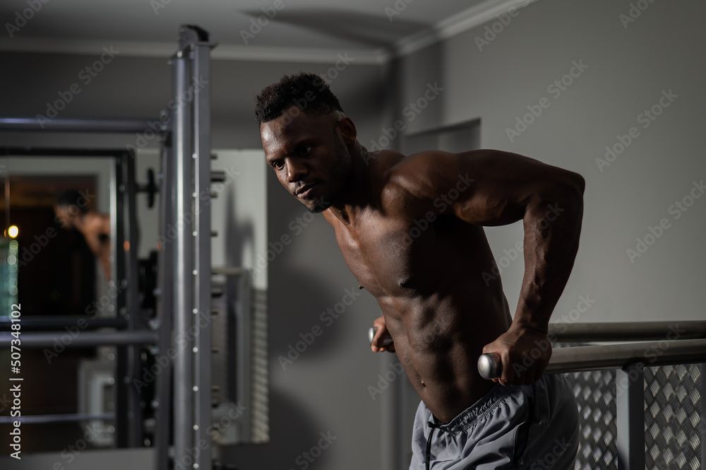 Handsome afro american man doing parallel bars exercise in gym. Handsome afro american man doing parallel bars exercise in gym.