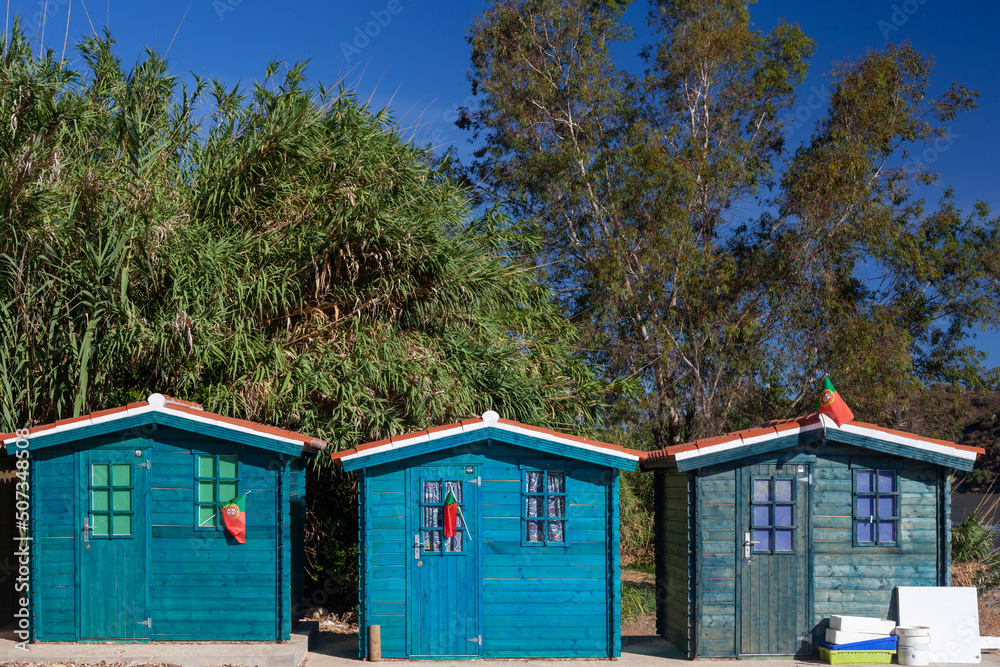 long shot of three colorful fishermen's huts near the Rio Guadiana on the Spanish-Portuguese border