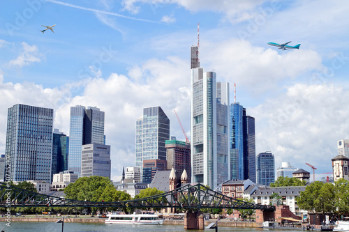 Frankfurt - European city skyline. Airplanes are flying in high flight. Skyscraper buildings in Germany on blue sky background. Business and Financial Center Frankfurt Main. Travel Destinations concep