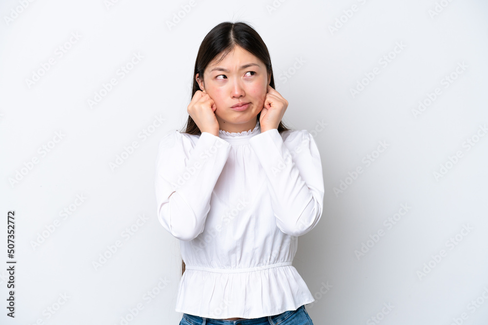 Young Chinese woman isolated on white background frustrated and covering ears Young Chinese woman isolated on white background frustrated and covering ears